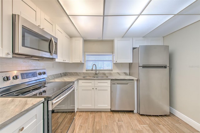 kitchen with white cabinets, light wood-type flooring, sink, and appliances with stainless steel finishes