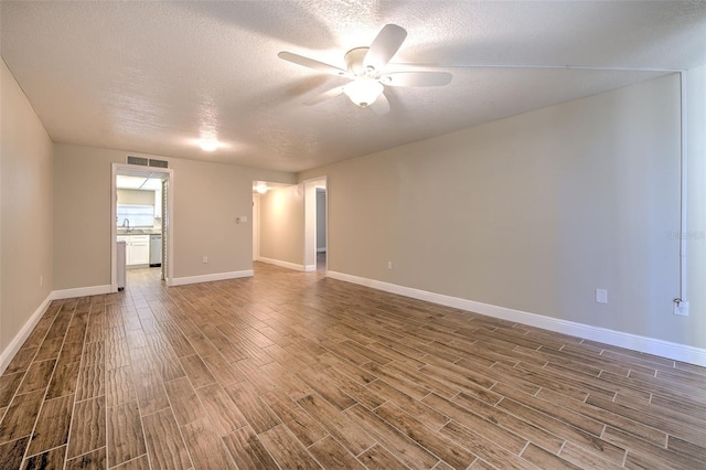 spare room featuring hardwood / wood-style floors, ceiling fan, and a textured ceiling