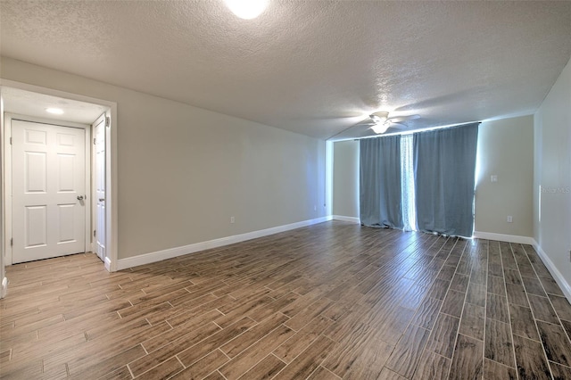 unfurnished room with ceiling fan and a textured ceiling