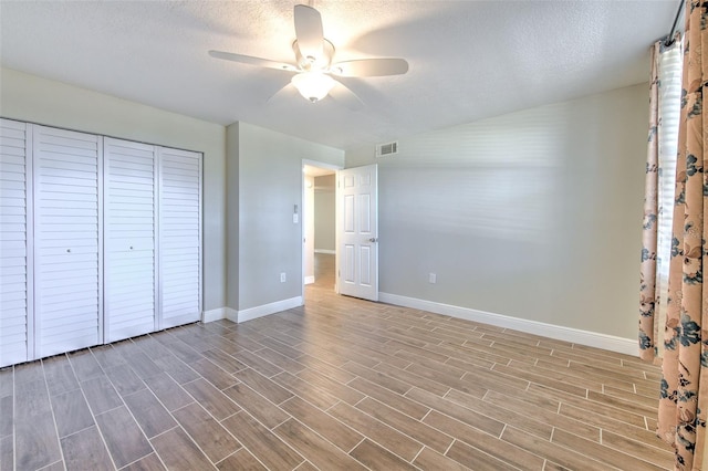 unfurnished bedroom with ceiling fan, a closet, and a textured ceiling