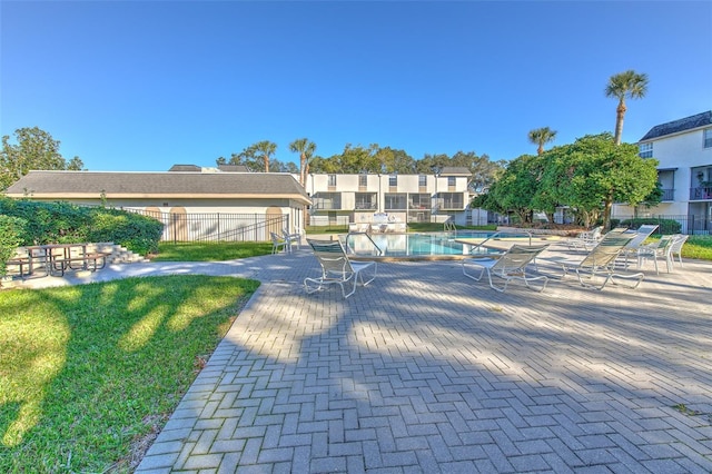 view of pool with a patio and a lawn