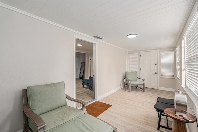 sitting room featuring crown molding and light hardwood / wood-style flooring