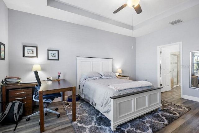 bedroom featuring a raised ceiling, ceiling fan, and dark hardwood / wood-style floors