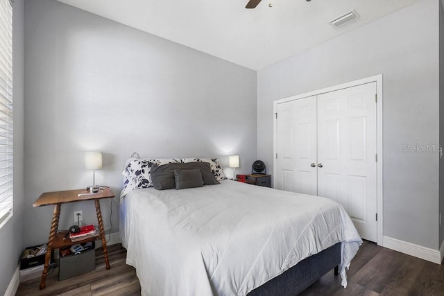 bedroom with ceiling fan, dark wood-type flooring, and a closet