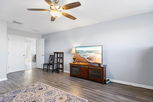 living room with ceiling fan and dark hardwood / wood-style floors