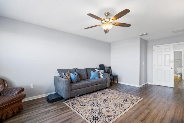 living room featuring ceiling fan and dark wood-type flooring