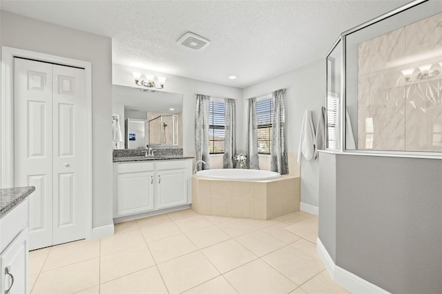 bathroom featuring vanity, shower with separate bathtub, a textured ceiling, and tile patterned flooring