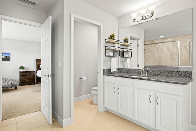 bathroom with vanity, tile patterned floors, toilet, a textured ceiling, and walk in shower