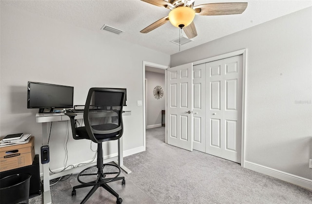 office space with visible vents, baseboards, carpet, a textured ceiling, and a ceiling fan