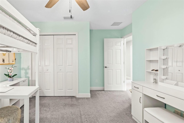 bedroom featuring light carpet, a closet, and ceiling fan