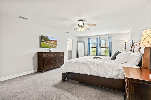 carpeted bedroom featuring ceiling fan and a textured ceiling