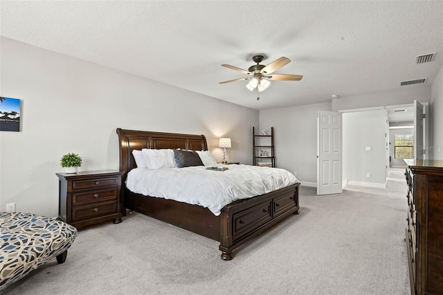 carpeted bedroom featuring ceiling fan and a textured ceiling