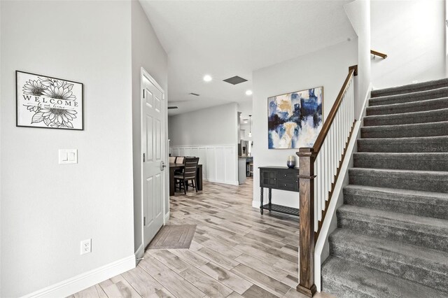 interior space with a wainscoted wall, recessed lighting, and wood finished floors