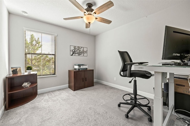 home office featuring carpet flooring, a ceiling fan, baseboards, and a textured ceiling