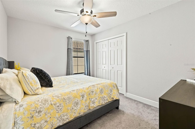 carpeted bedroom with a ceiling fan, baseboards, a closet, and a textured ceiling