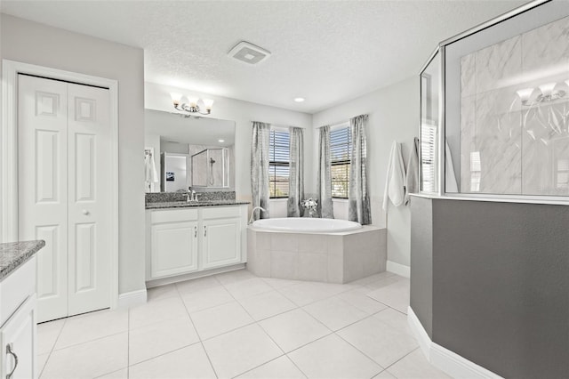 bathroom featuring a textured ceiling, a tile shower, tile patterned flooring, a bath, and vanity