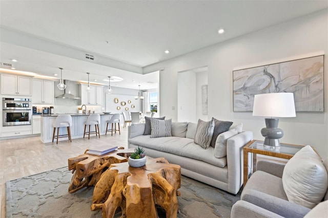 living room with light hardwood / wood-style flooring and sink