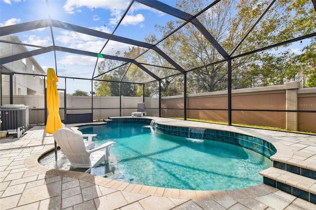 view of pool featuring pool water feature, a patio, a lanai, and central air condition unit