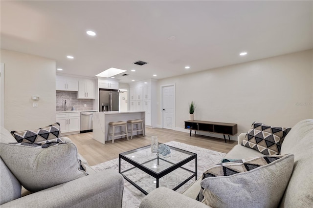 living room featuring light wood-type flooring and sink