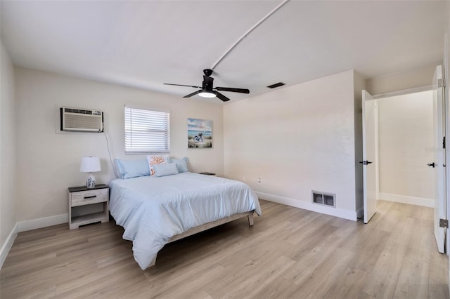 bedroom with an AC wall unit, ceiling fan, and light hardwood / wood-style flooring