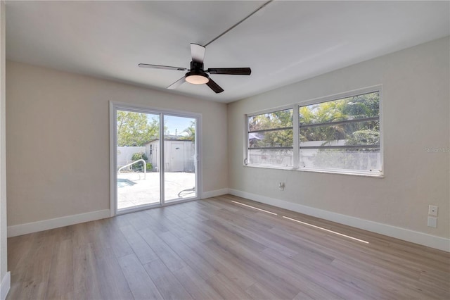 spare room with a wealth of natural light, light hardwood / wood-style flooring, and ceiling fan