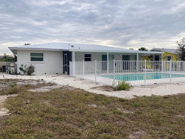 rear view of house with a patio area, a fenced in pool, and central AC