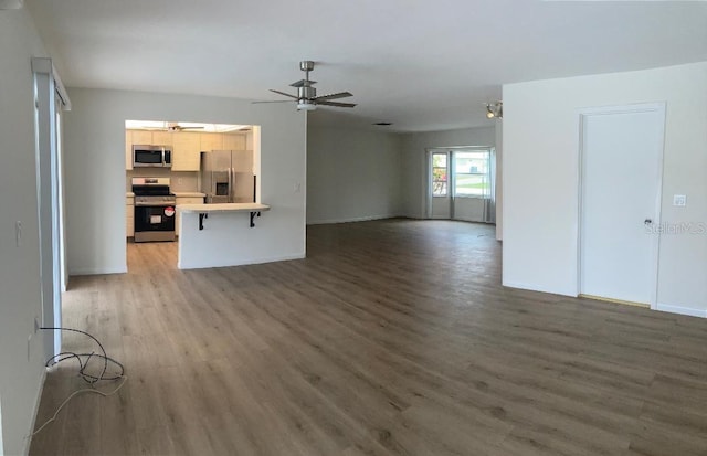 unfurnished living room featuring dark hardwood / wood-style floors and ceiling fan