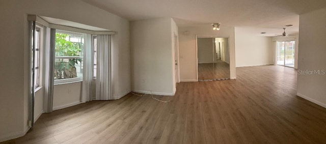 empty room with ceiling fan and light hardwood / wood-style flooring