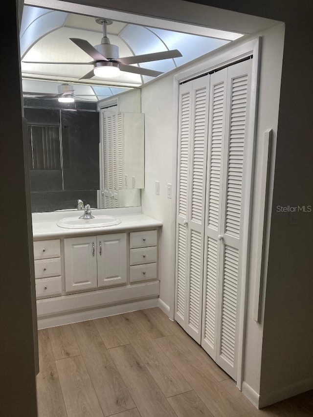 bathroom with wood-type flooring, vanity, and ceiling fan