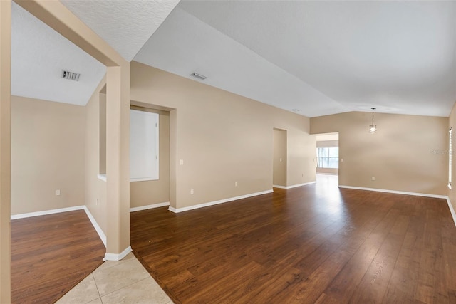 spare room featuring hardwood / wood-style floors and lofted ceiling