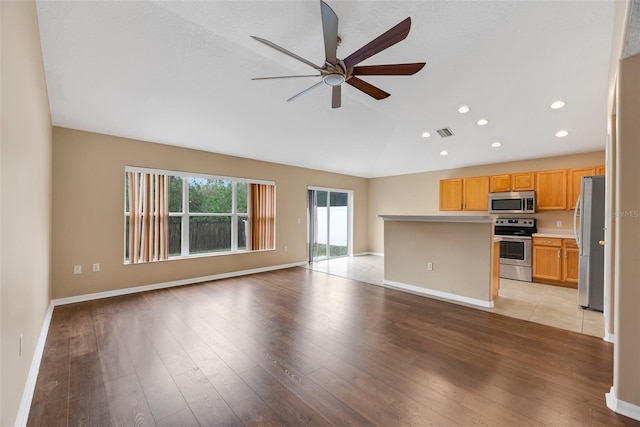 interior space featuring ceiling fan, light hardwood / wood-style floors, and appliances with stainless steel finishes