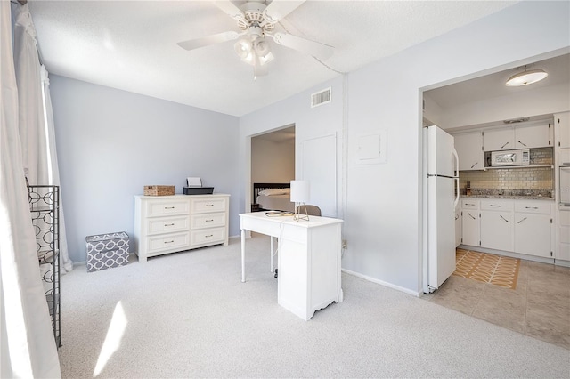 carpeted bedroom with ceiling fan and white fridge