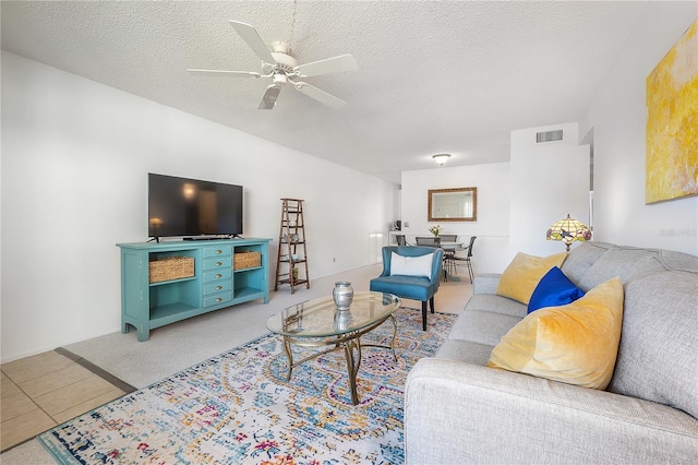 tiled living room featuring ceiling fan and a textured ceiling