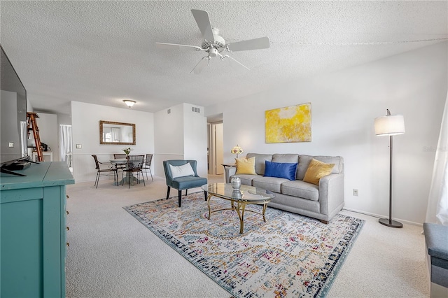 carpeted living room with a textured ceiling and ceiling fan