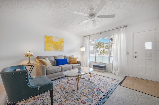 carpeted living room with ceiling fan and a textured ceiling