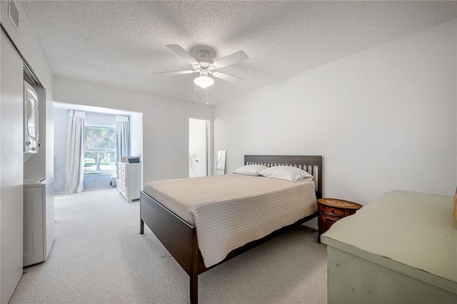 carpeted bedroom featuring ceiling fan and a textured ceiling