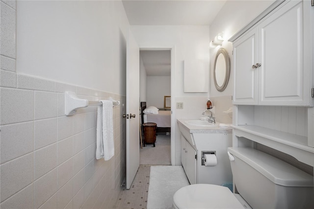 bathroom with tile patterned flooring, vanity, and tile walls