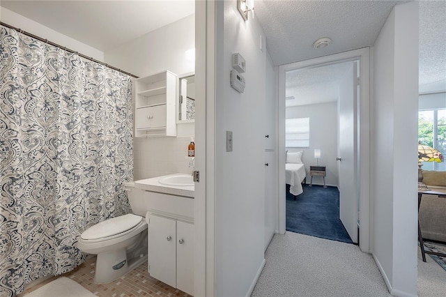 bathroom with vanity, a textured ceiling, and toilet