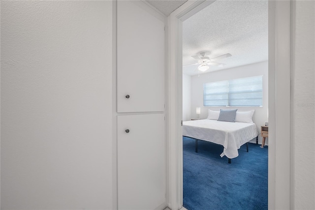 bedroom with carpet, a textured ceiling, and ceiling fan