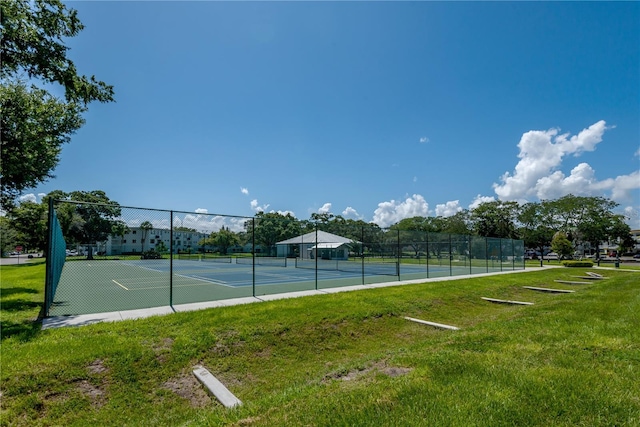 view of tennis court featuring a yard