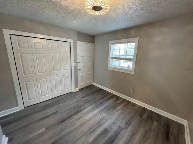 unfurnished bedroom featuring a textured ceiling and dark hardwood / wood-style floors