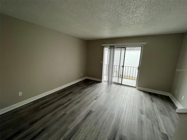 spare room featuring hardwood / wood-style floors and a textured ceiling