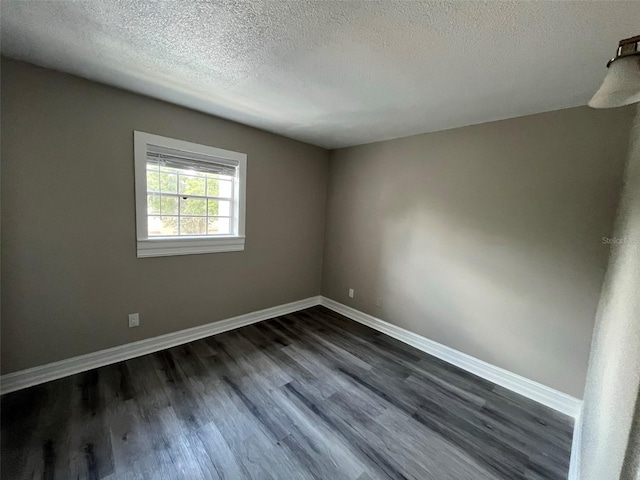 unfurnished room with a textured ceiling and dark hardwood / wood-style floors