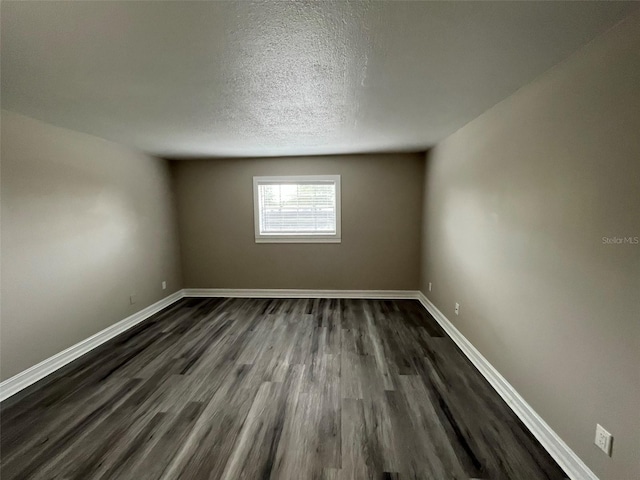 unfurnished room with a textured ceiling and dark hardwood / wood-style flooring