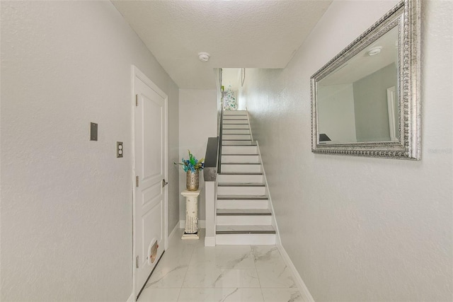 stairs featuring a textured ceiling