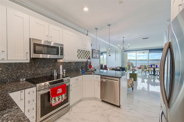 kitchen with white cabinetry, stainless steel appliances, an inviting chandelier, kitchen peninsula, and pendant lighting