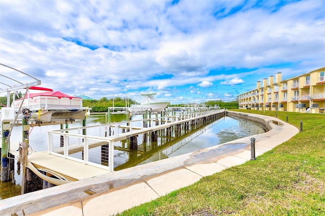 dock area featuring a lawn and a water view