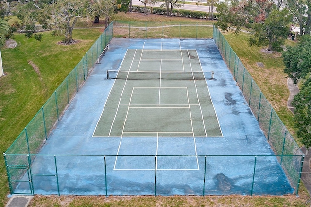 view of tennis court featuring a lawn