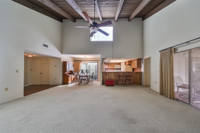 unfurnished living room with carpet floors, a high ceiling, and wooden ceiling