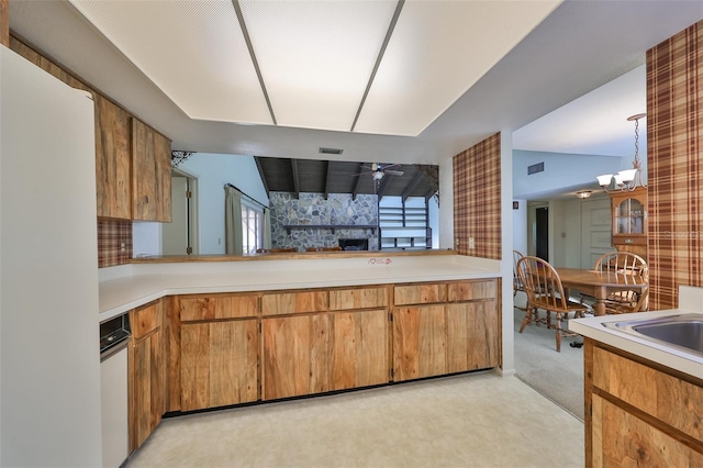 kitchen with light carpet, pendant lighting, ceiling fan with notable chandelier, and vaulted ceiling